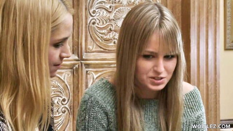 Two blonde lesbians in green sweaters gazing intimately close-up ready to kiss