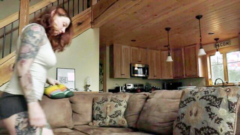 Tattooed redhead mommy in tight top and shorts holds massive dildo, teasing worship