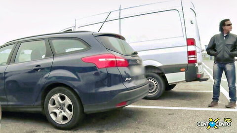 Alex Magni stands by cars in outdoor parking lot for Debby Love anal sex video