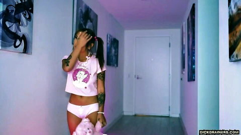 Tattooed Asian babe in pink crop top and panties walks purple-lit hallway holding teddy bear covering face