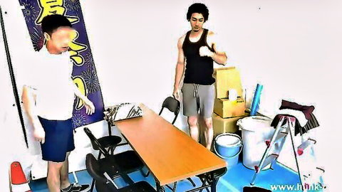 Two young Japanese men unpacking boxes and arranging furniture in a cluttered room