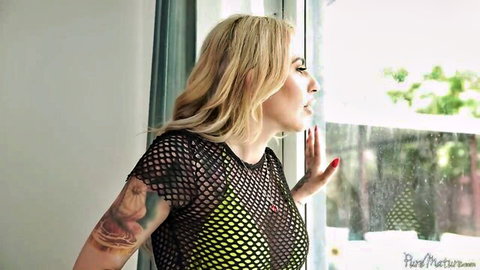 Sophia Deluxe in sheer mesh top, seductive pose by window