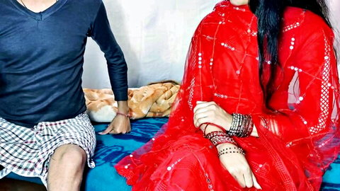 Sexy Indian wife in red saree sits teasingly with older man on bed ready for rough sex