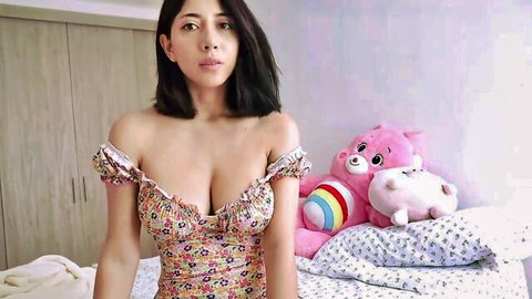 Latina beauty with big tits in low-cut floral dress teasing cleavage on bed with teddy bears