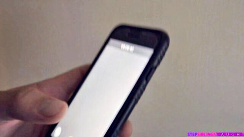 Hand holding black iPhone with blank screen in Step Sis Loves Me stepsister porn promo