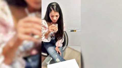 Seductive Indian college girl in floral top sipping drink
