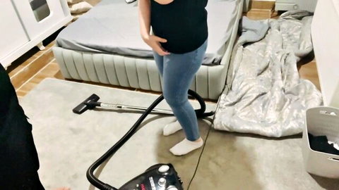 Sexy woman in tight jeans grips vacuum hose between legs teasing her pussy mound while cleaning