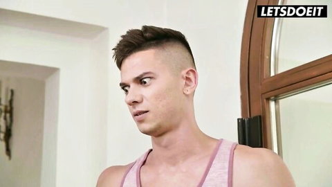 Handsome muscular guy in pink tank top looking sideways intensely