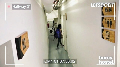 Young brunette with backpack walks down hostel hallway in tight jeans showing curvy ass