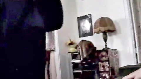 Empty cozy bedroom corner with vintage lamp, wooden shelf, hanging clothes and picture frame.