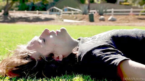 Payton Preslee lying sensually on grass in outdoor scene