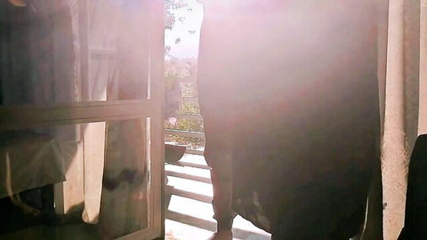 Curvy Desi housewife in black dress at sunny doorway, teasing view