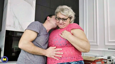 Young man passionately kisses busty BBW granny's neck while groping her tits from behind