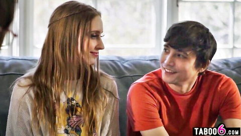 Wet brunette teen in sweater smiles at young guy on couch in taboo scene