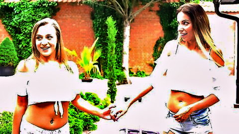 Two curvy brunettes in skimpy off-shoulder tops and ripped denim shorts holding hands teasing outdoors