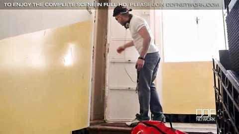 Handsome man in white tee and jeans stands on metal stairs with red bag in DDF teaser