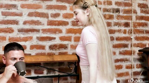 Blonde teen in pink crop top and skirt teases muscular guy sipping coffee against brick wall