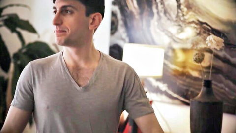 Charlie Forde smiling in gray V-neck shirt, casual portrait