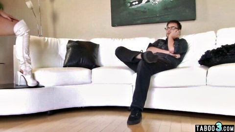 Sheena Ryder in white thigh-high boots teases seated man on couch