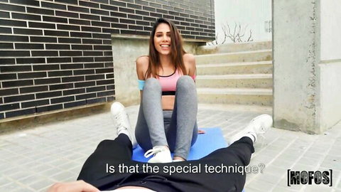 Baby Nicols in pink sports bra and leggings sits on partner's lap outdoors