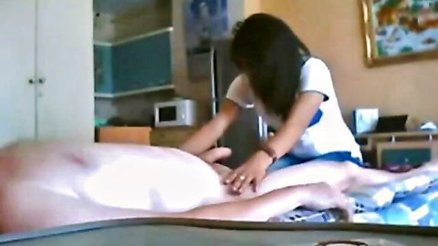 Thai woman in white top gives intimate massage to semi-nude man