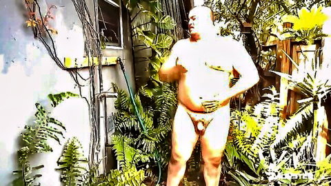 Bald muscular bear in tiny thong posing outdoors, teasing huge bulge