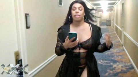 Ebony curvy woman in black lingerie struts seductively in hotel hallway