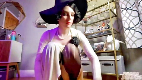 Busty cosplay babe in flapper hat and open white cardigan, kneeling with cleavage