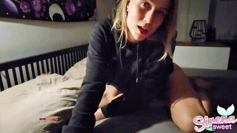SirenaSweet blonde in black hoodie, seductive bed pose mouth open