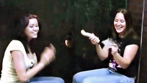 Two smiling brunettes in tank tops surprise with glory hole handjob
