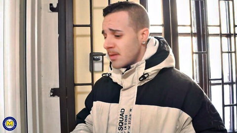 Buzzcut man with tears crying emotionally behind prison bars wearing squad jacket