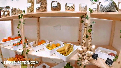 Colorful wooden shelves stocked with oranges, bananas, lemons, garlic, nuts and greens in a bright kitchen display.
