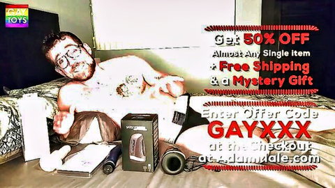 Muscular tattooed guy with glasses teases fleshlight masturbator on crotch surrounded by gay sex toys