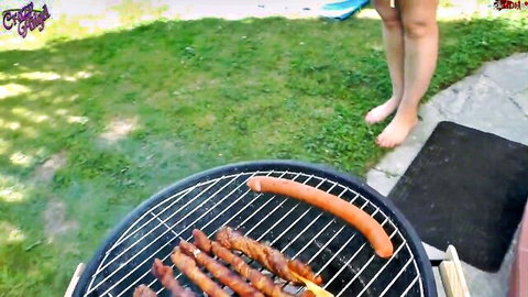 Barefoot MILF in blue thong stands by sizzling fat sausages on outdoor BBQ grill