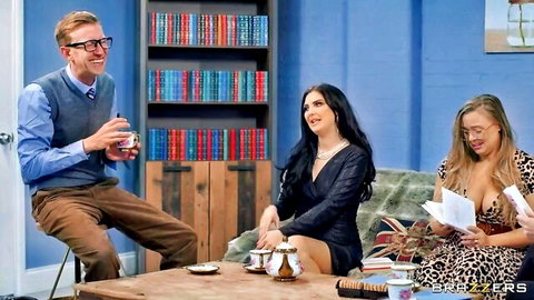 Busty brunette and blonde in sexy dresses chat with male host on Brazzers talk show set