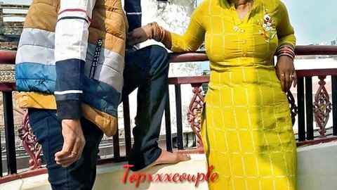 Desi couple in yellow dress and jacket teasing on balcony