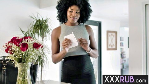 Sexy smiling ebony woman in tight tank top and skirt holding love note with red roses