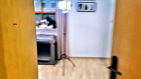 Blurry empty kitchen room setup with softbox light and tripod for amateur adult video shoot