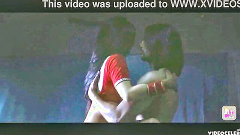Sexy Indian woman in red saree passionately hugs shirtless hunk, tits pressed against his bare chest