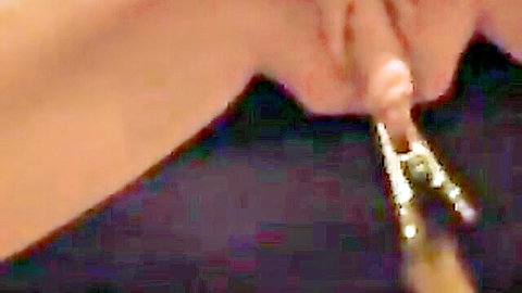 Close-up of mature woman's tied pussy with metal clamps exposing labia