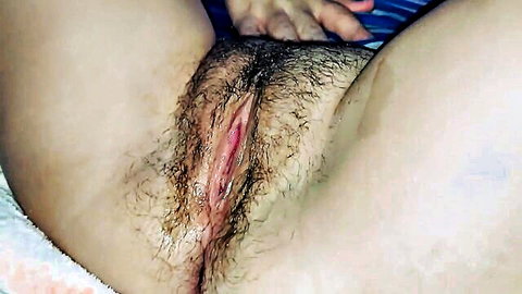 Close-up of wet hairy pussy spread open by hands in amateur video