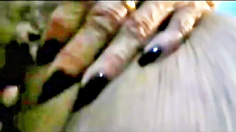Mature hands with long black nails gripping light-haired head in intimate close-up