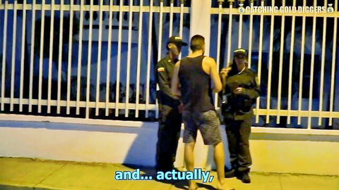 Police officers confronting shirtless man in tense nighttime encounter