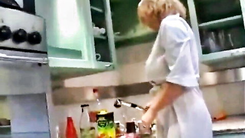 Blonde MILF teasing big tits in kitchen apron