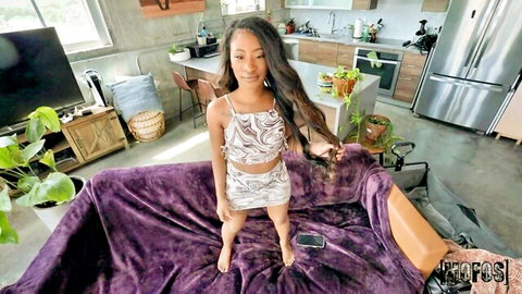 Petite ebony woman in wavy top and mini skirt posing seductively