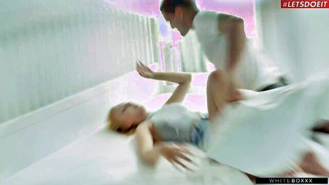 Blonde woman in gray top and white skirt getting fucked missionary style by muscular guy
