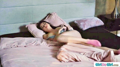 Topless Asian beauty with big tits lying seductively on bed in pink panties