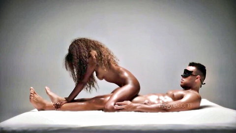 Nude curly-haired ebony babe straddling muscular black man in sensual cowgirl pose on bed