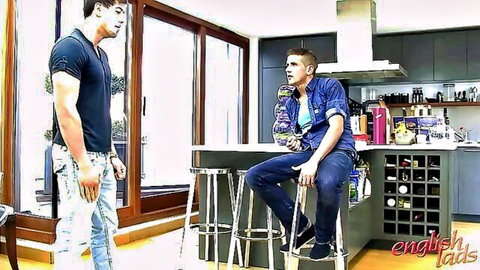 Two muscular white guys chatting casually, one standing one sitting, English lads style