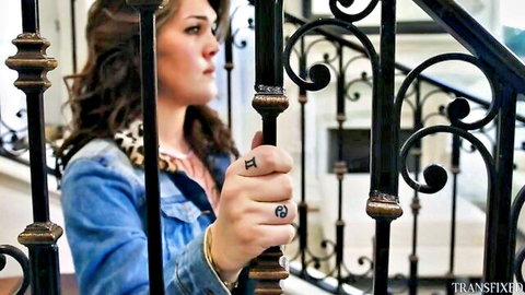 Trans star Daisy Taylor grips railing in denim jacket, sultry side glance